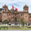 people walking near Cusco Cathedral in Peru under white and blue sky